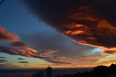 Low angle view of buildings against cloudy sky during sunset