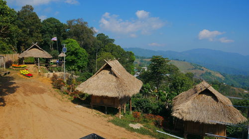 Houses by trees and mountains against sky