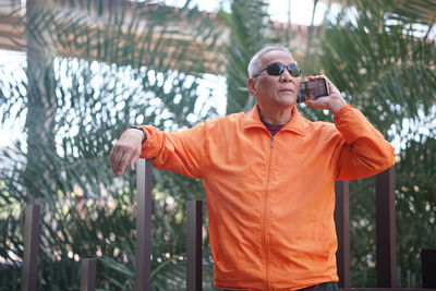 Portrait of young man standing against trees