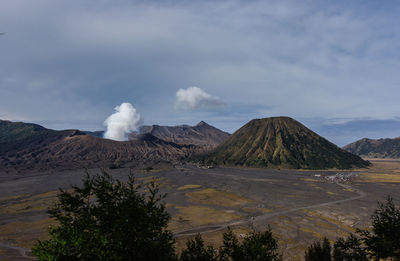 Smoke emitting from volcanic mountain against sky