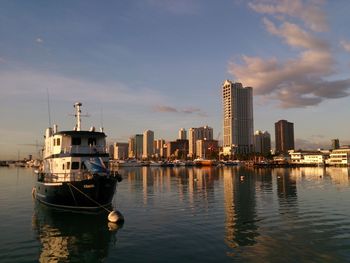Nautical vessel on water in city against sky