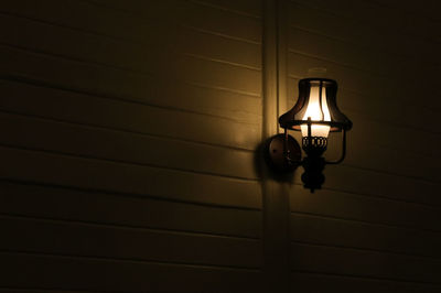 Low angle view of illuminated light mounted on wall at home