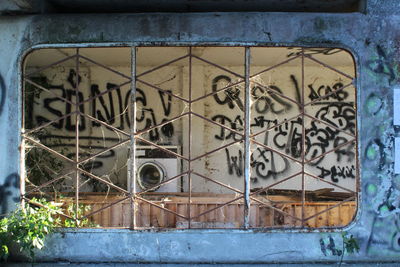 Abandoned building seen through metal window