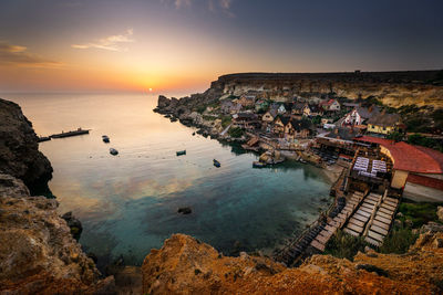 Popeye village from malta scenic view of sea against sky during sunset