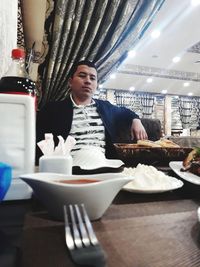 Mid adult woman having food in restaurant