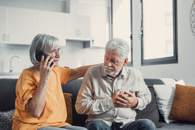 Side view of senior woman using mobile phone while sitting at home