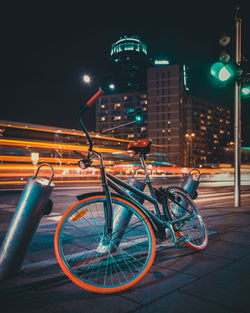 Bicycle parked on street in city at night