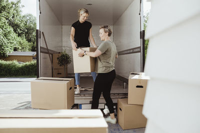 Women unloading boxes from moving van