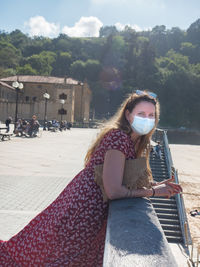 Woman sitting in front of built structure