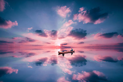 People sailing boat in calm river during sunset