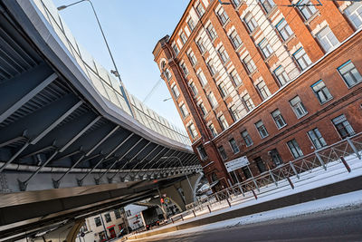 Low angle view of bridge and buildings against sky