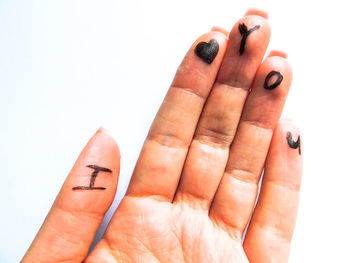 Close-up of human hand over white background