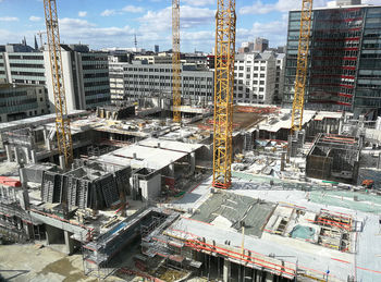 High angle view of construction site by buildings against sky