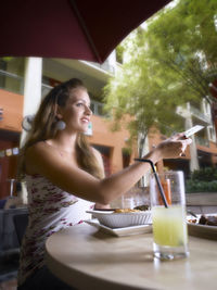 Woman paying with credit card at outdoor cafe