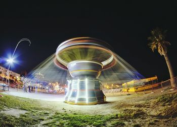 Light trails in amusement park at night