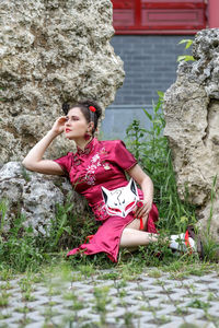 Portrait of young woman sitting on rock