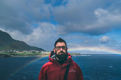 Portrait of man standing in sea against sky