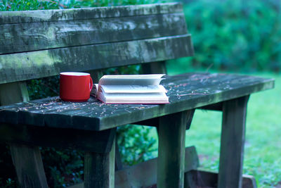 Book with coffee cup on bench