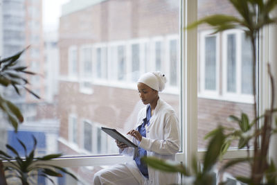 Female doctor standing and using digital tablet