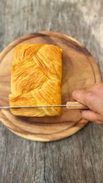 Cropped hand of person holding cutting board