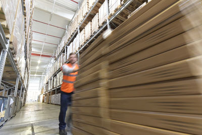 Man in factory hall transporting goods