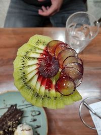 Close-up of hand holding fruit on table