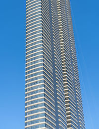 Low angle view of modern building against blue sky