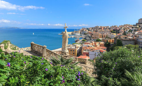 Scenic view of sea by buildings against blue sky