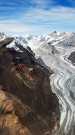 Scenic view of snowcapped mountains against cloudy sky