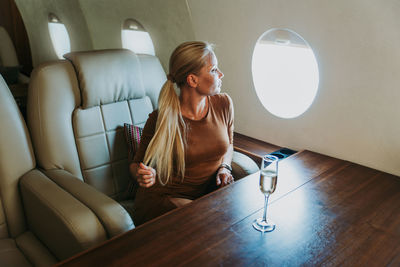 Full length of woman sitting on seat