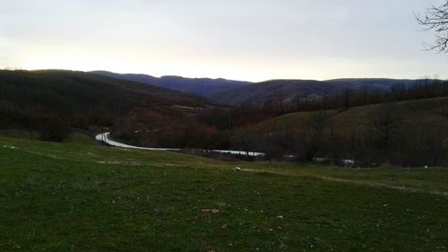 Scenic view of field and mountains against sky