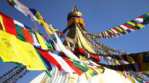 Low angle view of multi colored flags against building in kathmandu 