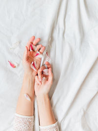 Top view on woman's hands with pink flower petals. symbol of spring, tenderness and fragility.