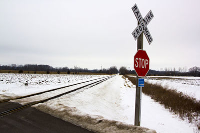 Road sign on snow against clear sky