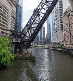 Open drawbridge over chicago river amidst modern buildings in city