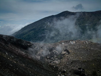 Smoke emitting from volcanic mountain against sky