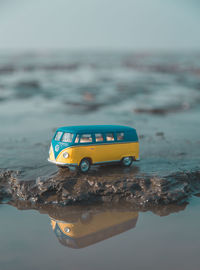 Yellow toy car on sea shore