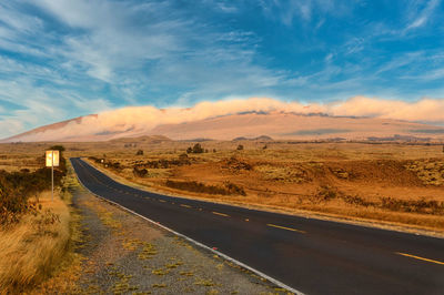 Road by landscape against sky