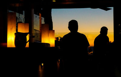 Silhouette man against orange sky