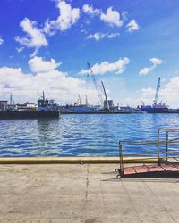 Boats moored at harbor against sky