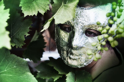 Close-up portrait of young woman with leaves