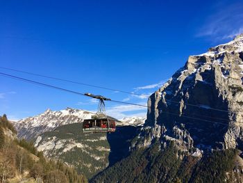 Overhead cable car and mountains against blue sky
