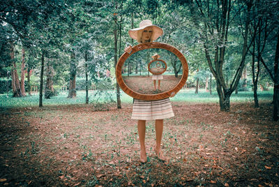 Portrait of girl standing by trees in forest