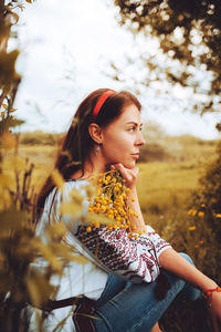 Photo of a smiling young woman in ethnic ukrainian shirt, enjoying the beautiful weekend getaway