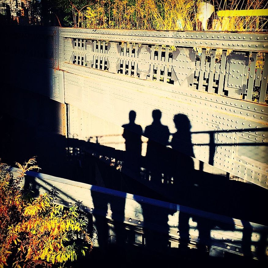 railing, group of people, nature, real people, men, sunlight, built structure, architecture, transportation, shadow, day, silhouette, high angle view, bridge, people, mode of transportation, nautical vessel, outdoors, water, lifestyles, canal