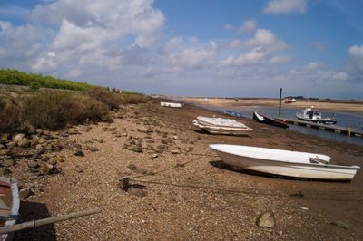 Boats moored on beach against sky