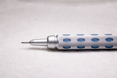 Close-up of pen on table against white background