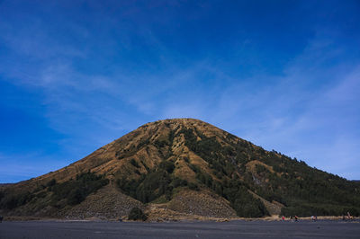 Scenic view of sea and mountains against blue sky