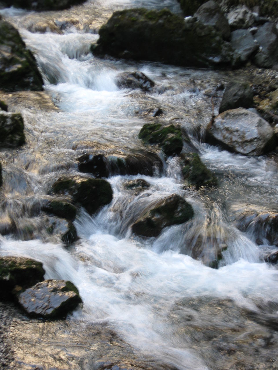 SCENIC VIEW OF WATERFALL ALONG ROCKS