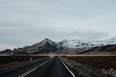 Road by mountain against sky